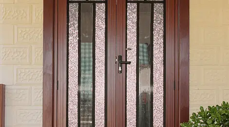 Elegant double front door with textured glass panels and dark wood frame offering both privacy and natural light Elegant double front door with textured glass panels and dark wood frame, offering both privacy and natural light.
